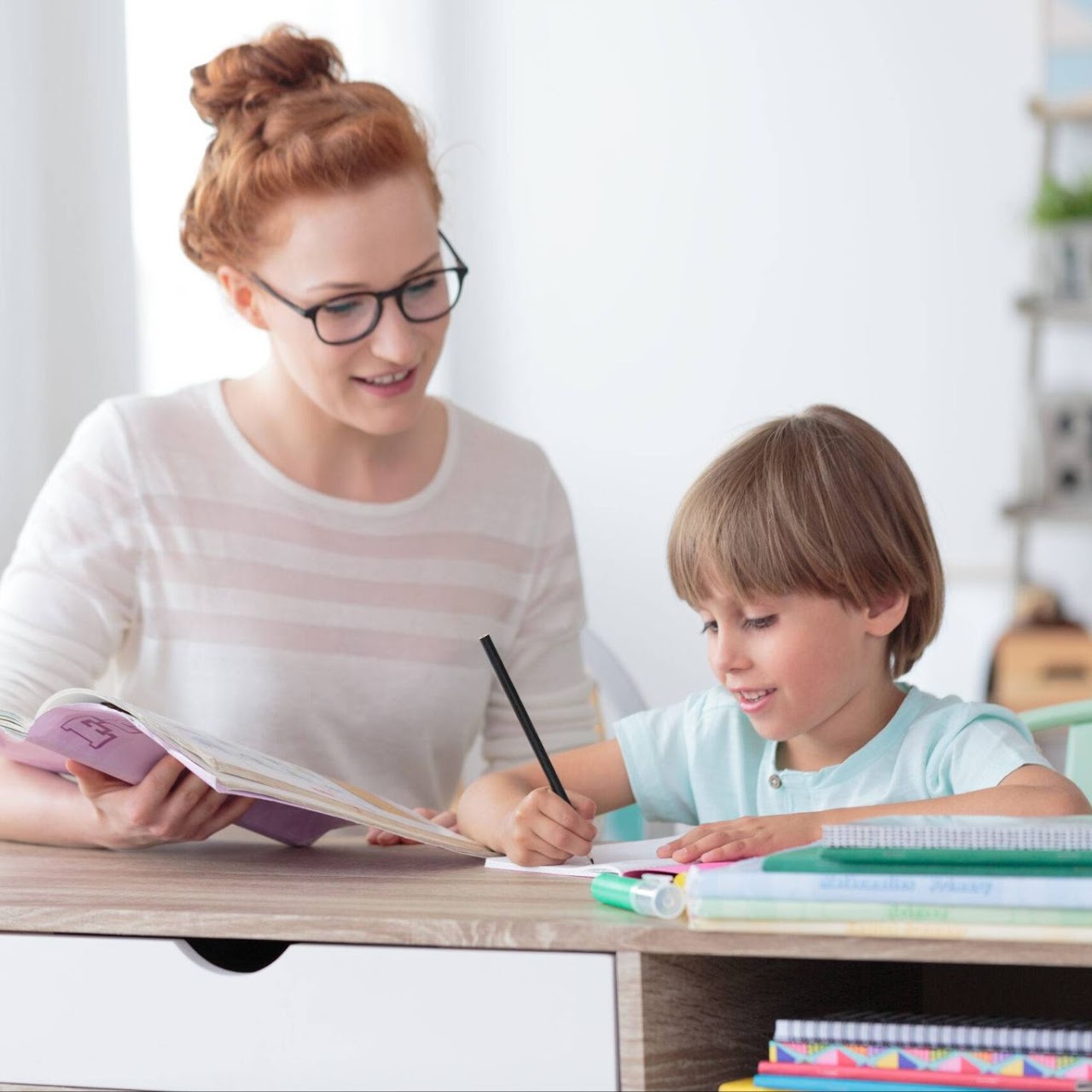 Tutor working with a young student on writing